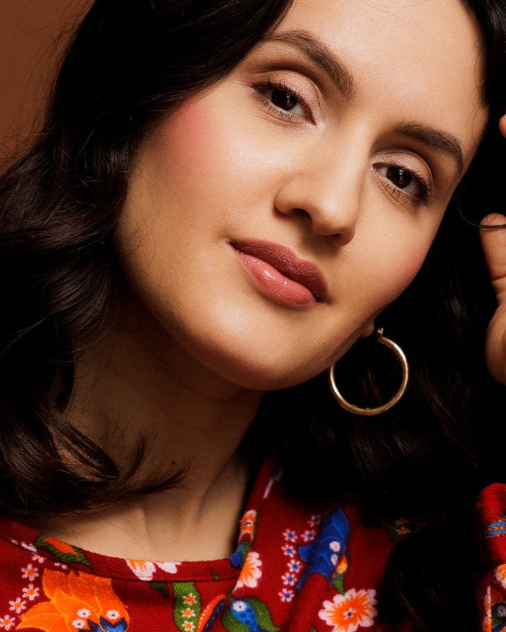 A young woman with an red colored flannel sweater with anatolian turkish floralprint